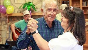 Heritage House Retirement Center resident John Coker, 73, dances with nurse Lori May Friday afternoon during a luau-themed cookout. Heritage House had events all week celebrating National Assisted Living Week. (Justin Sellers/The Vicksburg Post)