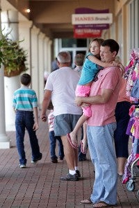 Brianna Andrews, 8, hugs her father Robert Andrews Saturday morning during the Shopping Extravaganza sponsored by Blackburn Nissan at the Outlets at Vicksburg. More than 500 ticketed shoppers turned out for the event which donated more than $13,000 to Hinds Community College DECA and Junior Auxiliary last year. (Justin Sellers/The Vicksburg Post)