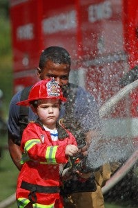 Oakley May-Sauntry, 3, practices using a fire hose Friday morning during the Vicksburg Fire Department Fire Prevention Program at City Pavilion. Local and state fire and law enforcement officials were at the program to educate and engage children in fire prevention. (Justin Sellers/The Vicksburg Post)