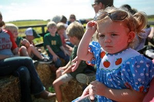 Maggie McBride, 2, raises her sunglasses to get a better look Wednesday morning during a hay ride at Farmer Jim's Pumpkin Patch and Corn Maze in Rolling Fork. (Justin Sellers/The Vicksburg Post)