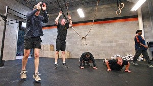 Gabe Gattle, from left, Eric Dupre, Kevin Torres and Daniel Brannon do burpees Thursday during a workout with Vicksburg CrossFit at the Purks Y. (Justin Sellers/The Vicksburg Post)