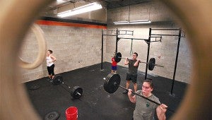 Kevin Torres, center, and Jessie Gates lift Thursday during a workout with Vicksburg CrossFit at the Purks Y. (Justin Sellers/The Vicksburg Post)
