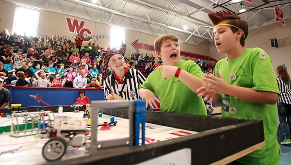 Beechwood Elementary Robo Rockers Will Custer, 11, center, and Brayden Robinson, 12, right, react after their robot performs a task Saturday afternoon during the FIRST LEGO League qualifier at Warren Central. (Justin Sellers/The Vicksburg Post)