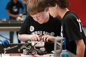 Bowmar Builders team members Benjamin Talbot, left, and Tyler Smith, both 11, program their robot to perform a task Saturday afternoon during the FIRST LEGO League qualifier at Warren Central. (Justin Sellers/The Vicksburg Post)