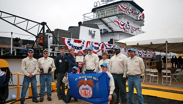 A FAMILY TRADITION: Emily Davis, 3, center, poses with the crew of the MV Emily Davis and others after the boat’s christening Tuesday morning at Magnolia Marine Transport.