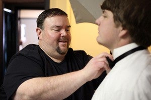 Griz Portrait Studio owner Chris Tillotson helps PCA senior Brandon Lynn with his bow tie during a senior portrait session Friday afternoon in his studio on Wisconsin Avenue. (Justin Sellers/The Vicksburg Post)
