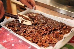 Cinnamon Tree owner Karen Ruggles mixes pecans into a pan of fudge Friday morning at the store on Washington Street. (Justin Sellers/The Vicksburg Post)