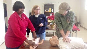 PUSH IT: Sylvia Gurtowski gives a quick CPR lesson to two prospective students inside the classroom Tuesday. (Cory Gunkel / The Vicksburg Post)