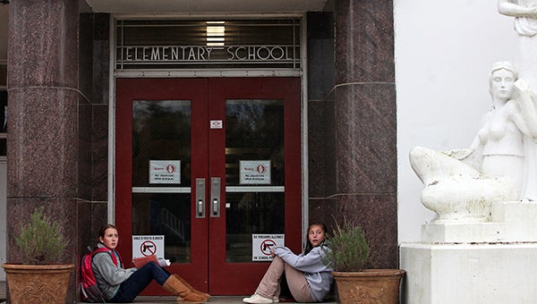 Waiting for a ride: Jane Hopson, left, sits across from her cousin Hannah Hopson, both 12, Monday afternoon at Bowmar Elementary School while they wait for their ride home after getting off school early due to inclement winter weather.