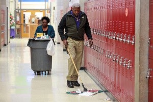 Michael and Donna Hall clean up the hallway after school at St. Aloysius. (Justin Sellers/The Vicksburg Post)