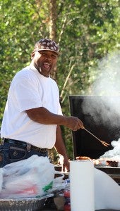 Joseph Branch cooks some meat on the grill at Delia’s Park in Marcus Bottom. The park is a gathering place for locals.