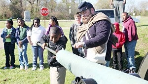 MUZZLELOADER: Jaedyn Cason swabs the barrel of a Civil War cannon with the help of Vicksburg National Military park ranger Jake Koch.