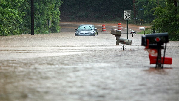 SATURATED: A car sits abandoned in the 4800 block of Halls Ferry Road after heavy rain caused floodwaters to overtake a large section of the street Monday. 