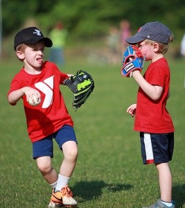 Noah Lewis, left, fields a ground ball while teammate Grady Fields watches during a YMCA tee ball game on Wednesday. (Justin Sellers/The Vicksburg Post)