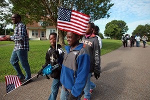 Vincent Durman II, from left, Robert Early, 8, and Asia Green walk out of the Vicksburg National Cemetery Friday morning after helping place American flags next to grave markers in preparation for Memorial Day. (Justin Sellers/The Vicksburg Post)