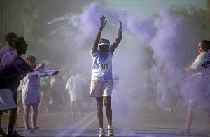 A runner is pelted with color powder Saturday morning on Washington Street during the United Way of West Central Mississippi's inaugural True Color Run. (Justin Sellers/The Vicksburg Post)