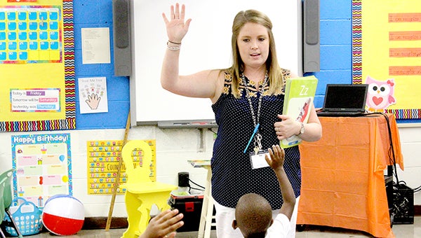 Pre-K teacher Savannah Horton has her students raise their hands during class Friday.